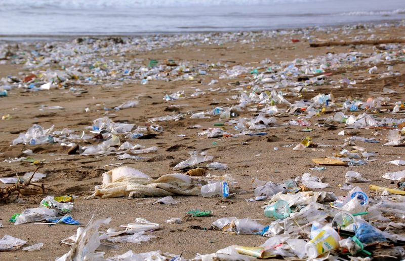 praia poluída com plásticos descartáveis