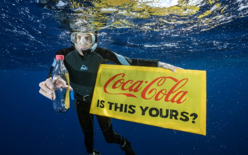 Mergulhador com garrafa da Coca-Cola